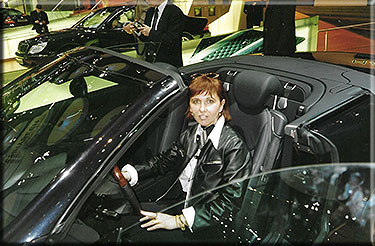 Paola Busato responsabile Codep al salone di Francoforte posa per una foto ricordo al volante della Maserati Spider.